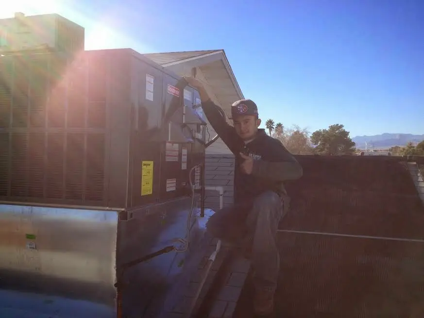 HVAC technician performing AC Tune-Up on a rooftop unit in North Arlington